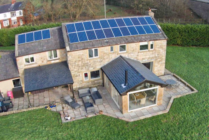 A lovely big home with solar panels on its roof.